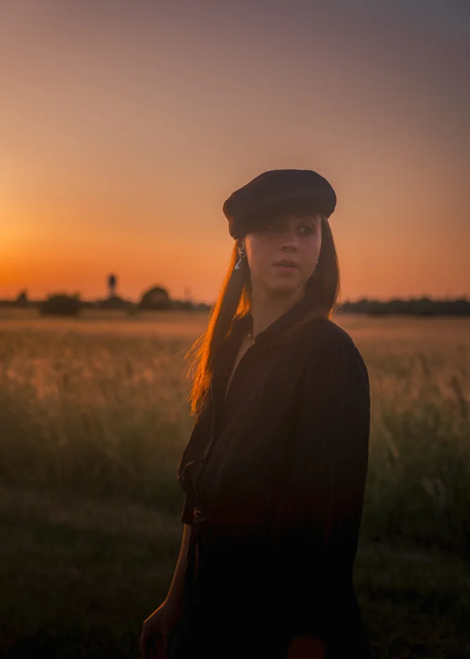 A woman in a field in warm sunset light