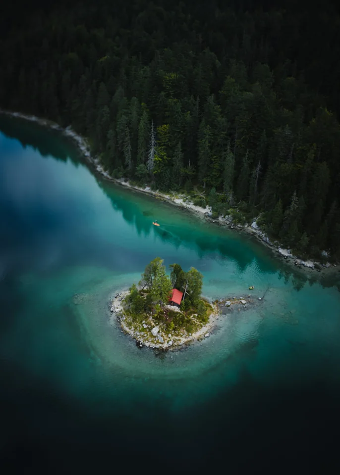 A small wooded island with a chapel in a turquoise lake